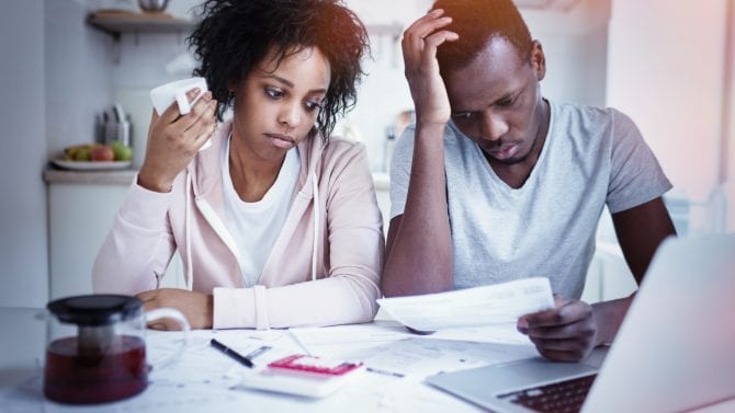 Couple worried over bills and financial documents, representing housing instability