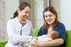 Doctor providing healthcare services to a mother holding a baby