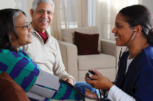 Healthcare provider checking an older adult's blood pressure.