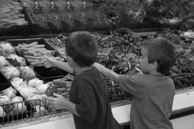 Children grocery shopping for vegetables