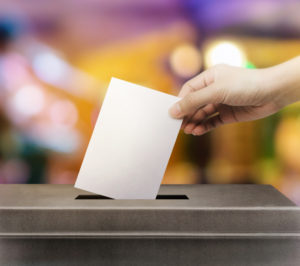 Image of people putting vote in an election box