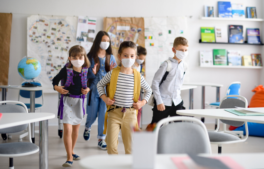 Group of children with face mask back at school after covid-19 quarantine and lockdown.