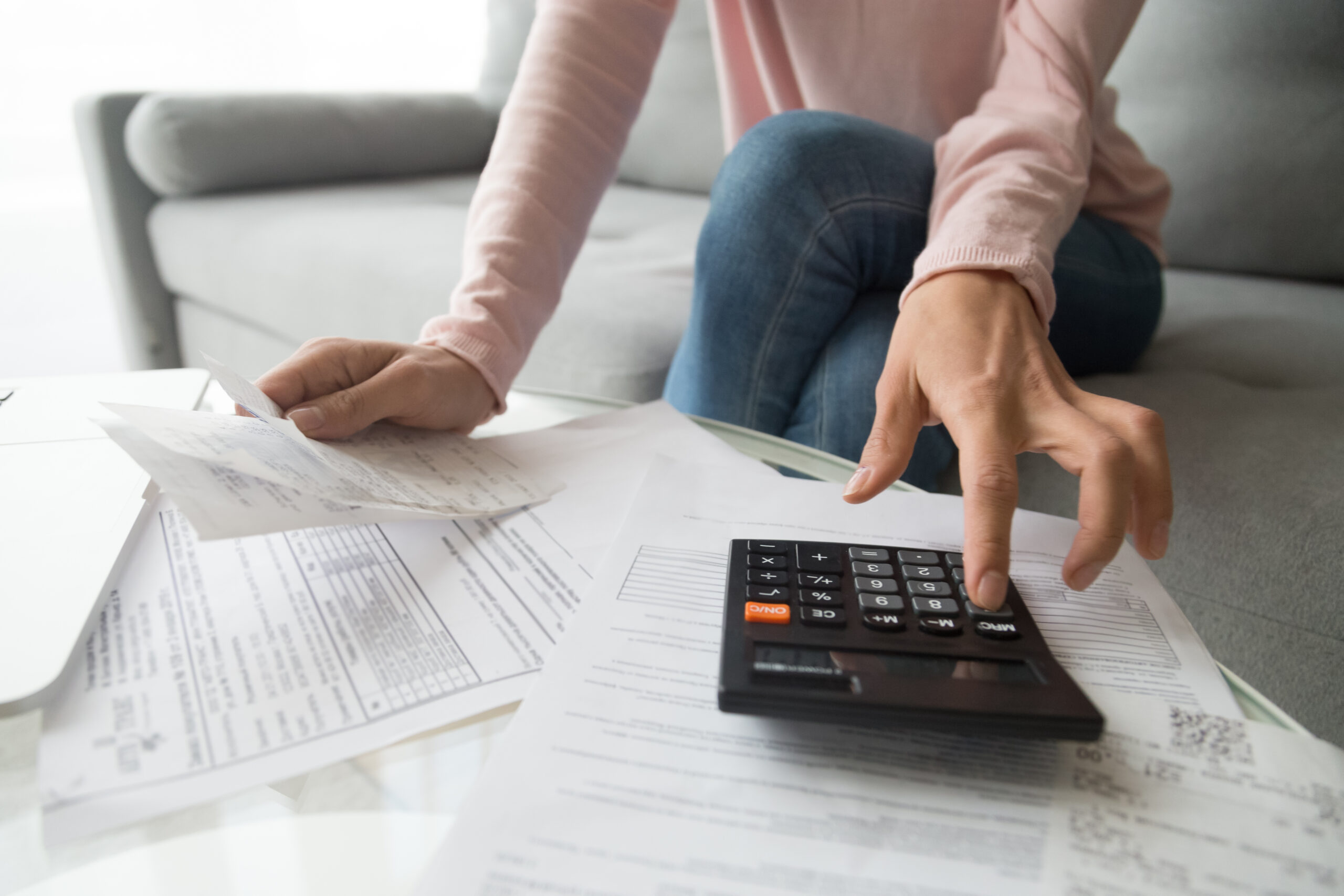 People calculating paperwork representing rent, bills, mortgages, and household finances.