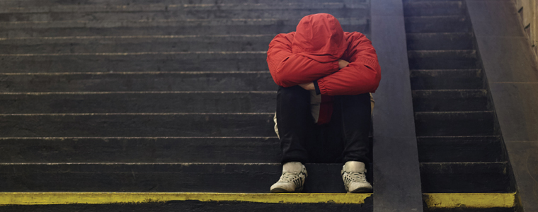 a person with their head in their lap while sitting on steps