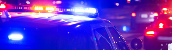 Police car with flashing emergency lights at night.
