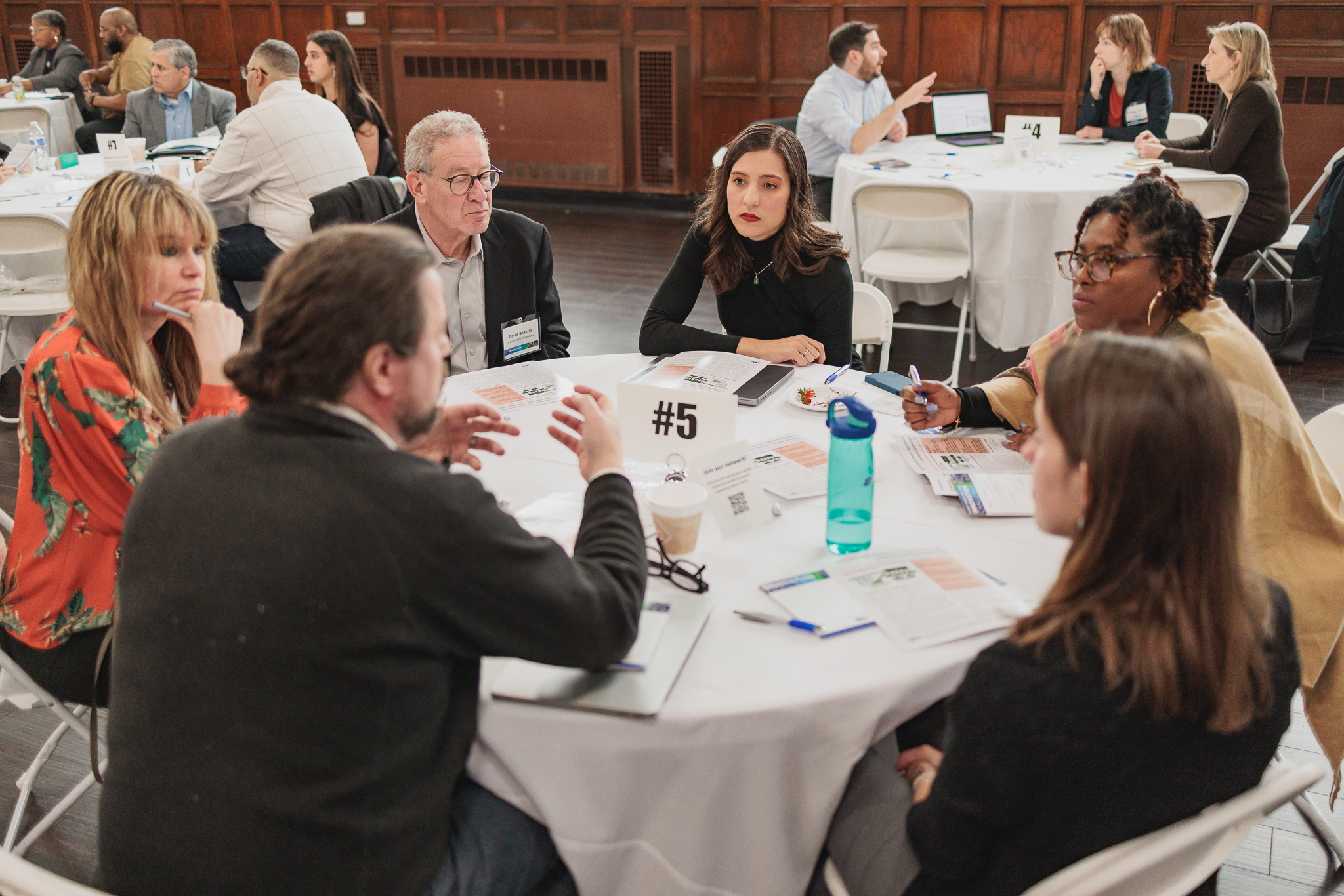 Participants and staff discussing around a table.