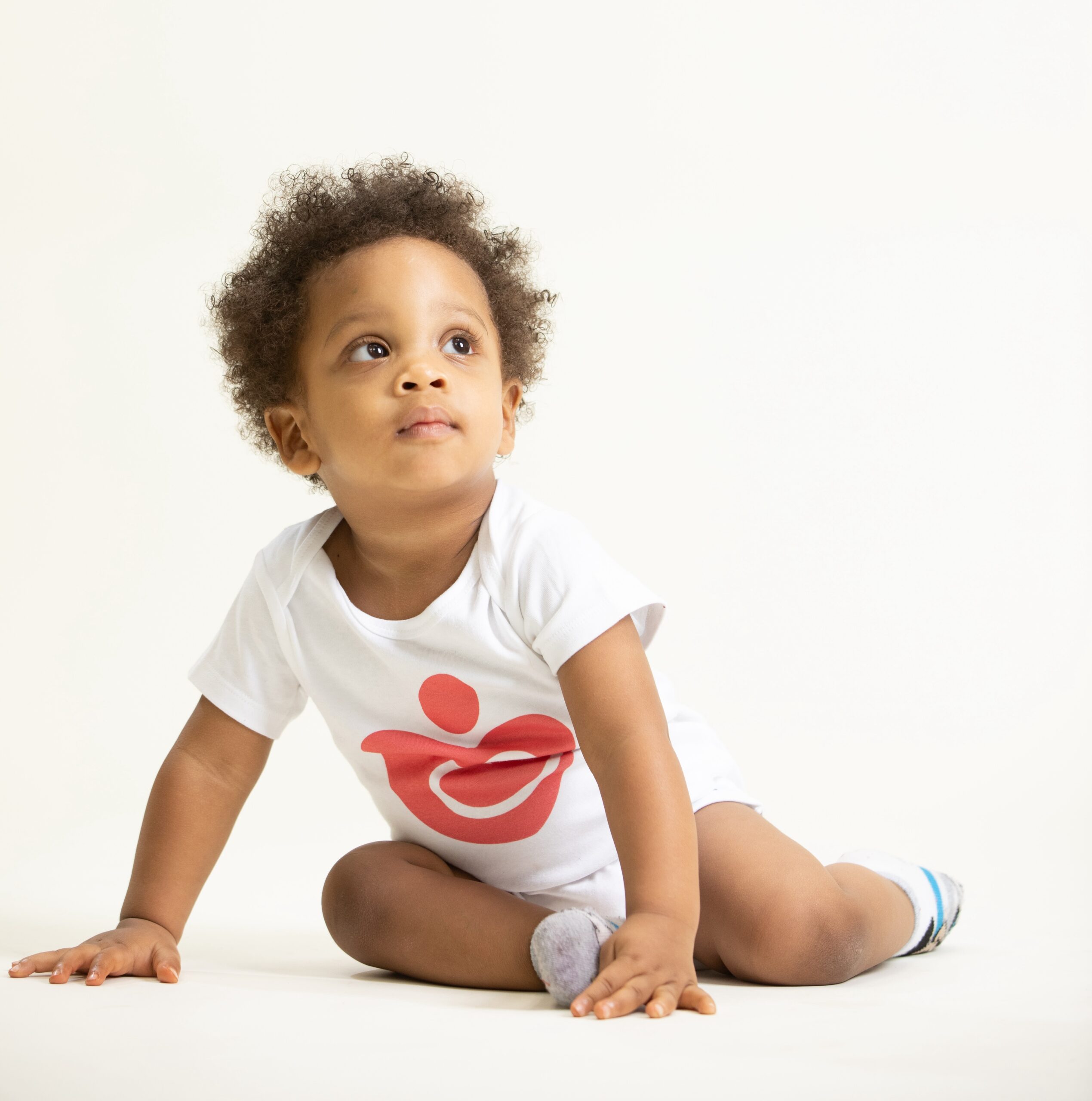 Baby in onesie with Rx Kids heart logo on it